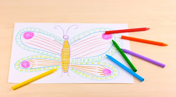 Dibujo infantil de mariposa y lápices sobre fondo de madera — Foto de Stock