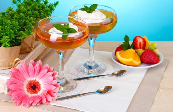 Geleia de frutas em copos e frutas na mesa no fundo azul — Fotografia de Stock