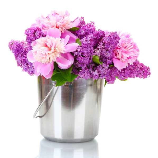 Hermosas flores de lila y peonías en cubo de metal aislado en blanco — Foto de Stock
