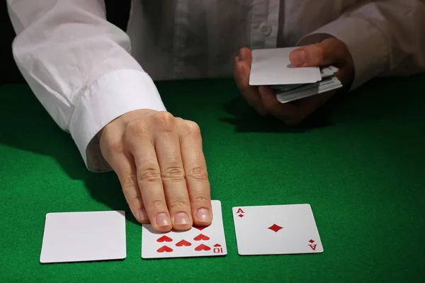 Cartões em mãos na mesa verde — Fotografia de Stock