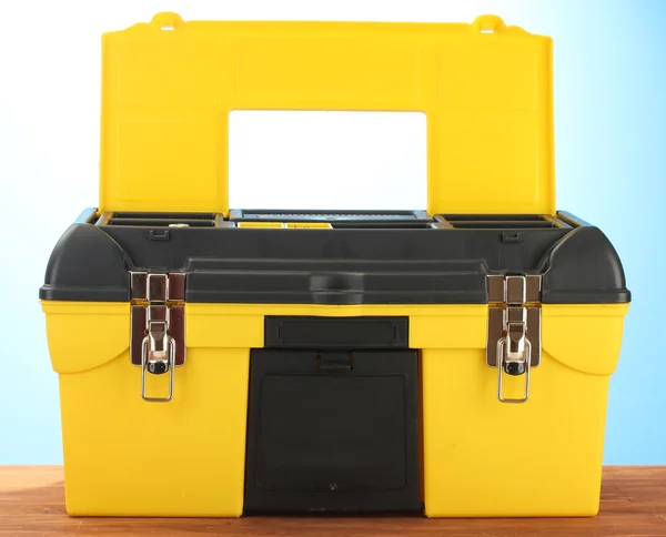 Gelber Werkzeugkasten auf blauem Hintergrund in Nahaufnahme öffnen — Stockfoto