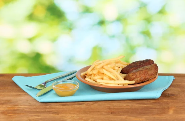 Brambory hranolky s hamburgery na štítku na zeleném pozadí detail — Stock fotografie