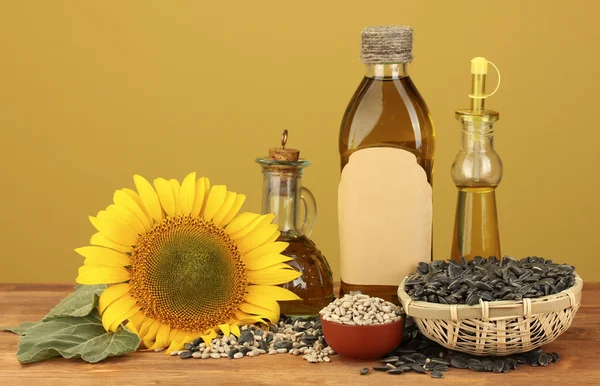 Sunflower oil and sunflower on yellow background — Stock Photo, Image