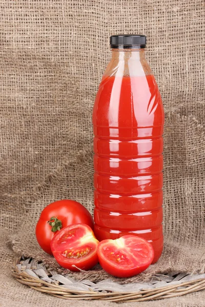Jus de tomate en bouteille sur fond de sac — Photo