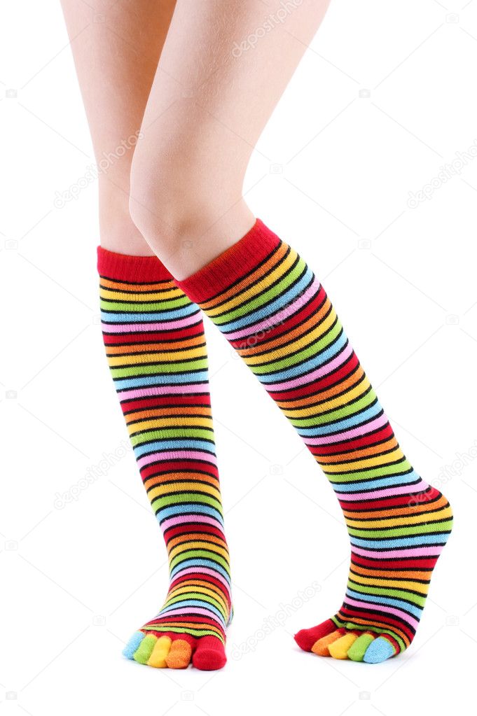 Female legs in colorful striped socks isolated on white