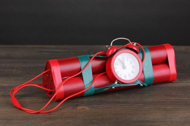 Timebomb made of dynamite on wooden table on grey background clipart