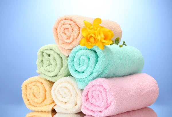 Красочные полотенца и цветы на голубом фоне — стоковое фото