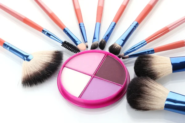 Make-up brushes and bright eyeshadow isolated on white — Stock Photo, Image