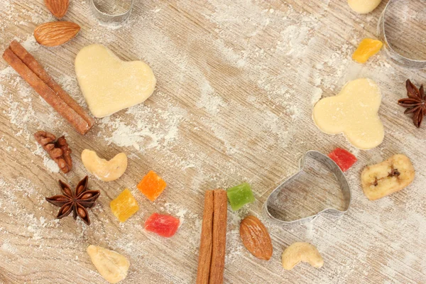 Kandierte Früchte, Nüsse, ungebackene Kekse und Formen für Plätzchen auf einem Holztisch in Großaufnahme — Stockfoto