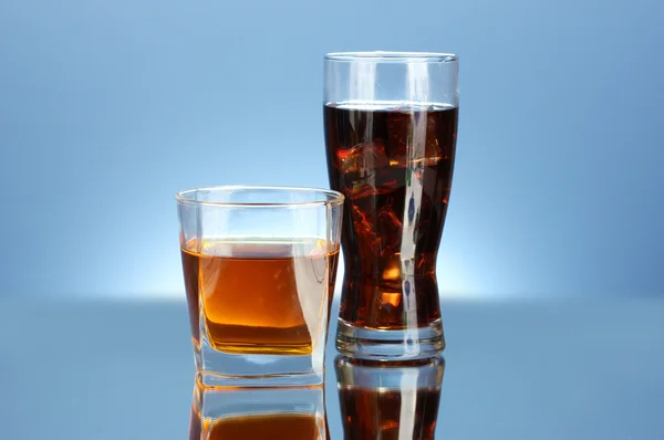 Sklenice whisky a sklenice cola na modrém pozadí detail — Stock fotografie