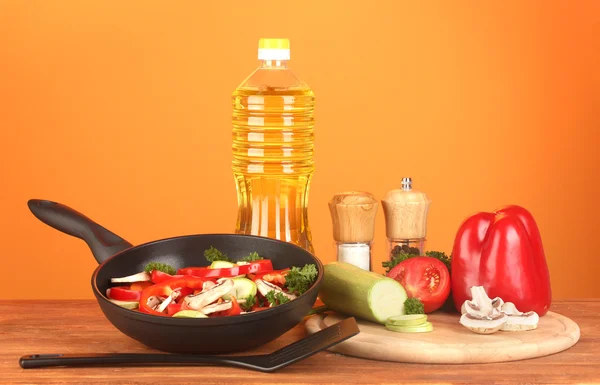 Stekpanna med grönsaker på röd bakgrund — Stockfoto