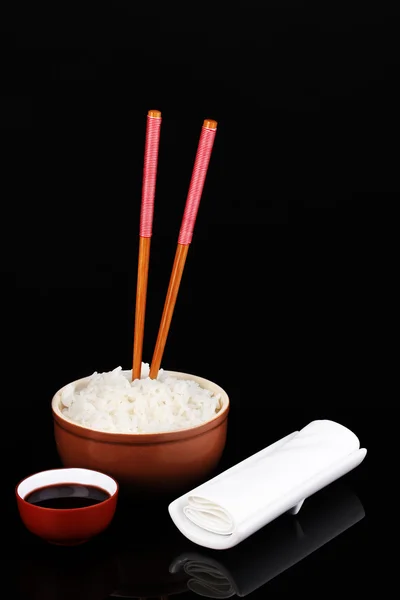 Tigela de arroz e pauzinhos isoalted em preto — Fotografia de Stock