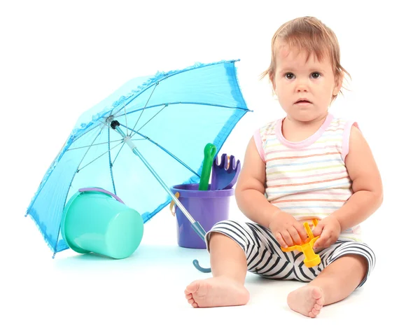 Симпатичный ребенок с ведром и лопатой рядом с зонтиком изолированы на белом — стоковое фото