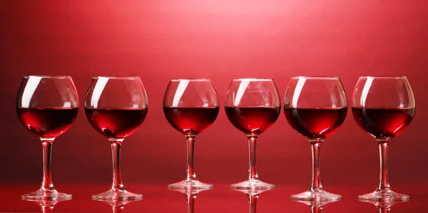 Wijnglazen op rode achtergrond — Stockfoto