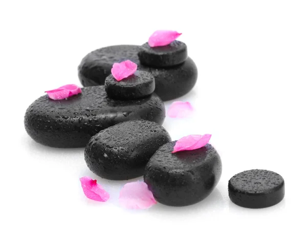 Wellness-Steine mit Tropfen und rosa Blütenblättern isoliert auf weiß — Stockfoto