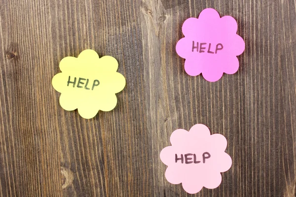 Help written on stickers on wooden background — Stock Photo, Image