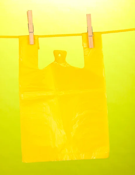 Cellophane bag hanging on rope on green background — Stock Photo, Image