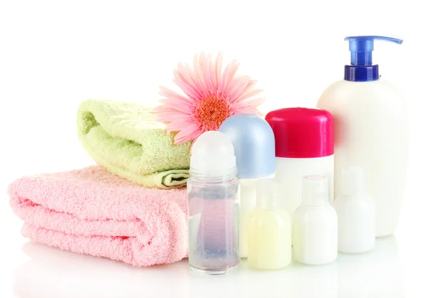 Botellas de cosméticos con toallas y flores aisladas en blanco —  Fotos de Stock
