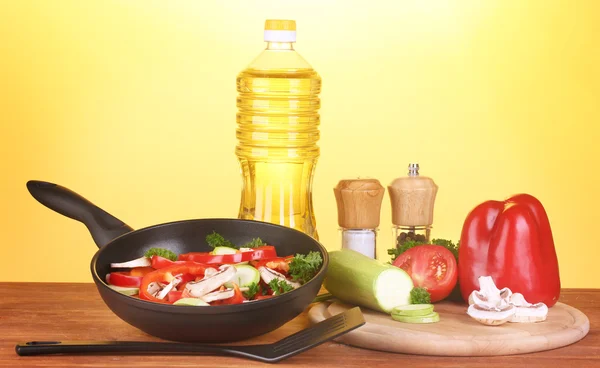 Pfanne mit Gemüse auf gelbem Hintergrund — Stockfoto