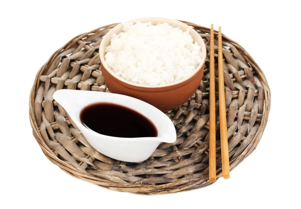 Cuenco de arroz y palillos en estera de mimbre isoalted en blanco —  Fotos de Stock