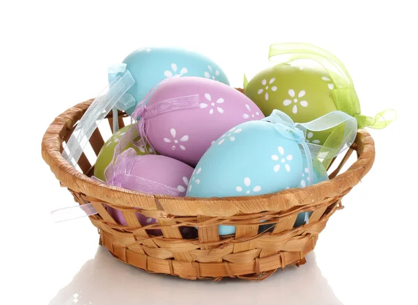 Цветные пасхальные яйца в корзине изолированы на белом — стоковое фото