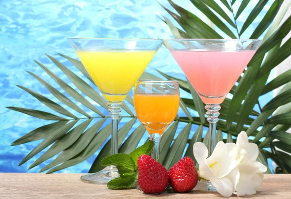Cocktail esotici e fiori sul tavolo su sfondo blu del mare — Foto Stock