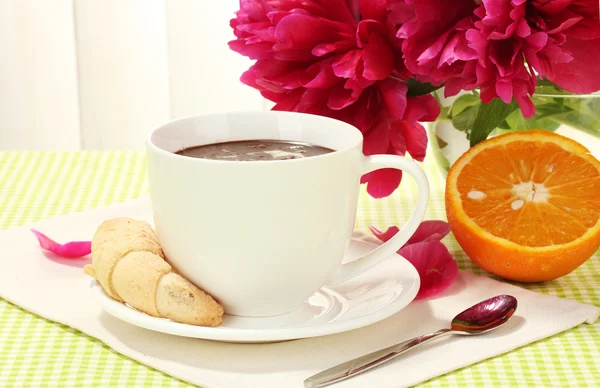 Φλιτζάνι ζεστή σοκολάτα, μπισκότα και λουλούδια στο τραπέζι στο café — Φωτογραφία Αρχείου