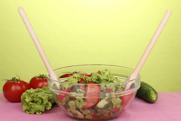 Frisk salat med tomater og agurker på grøn baggrund - Stock-foto