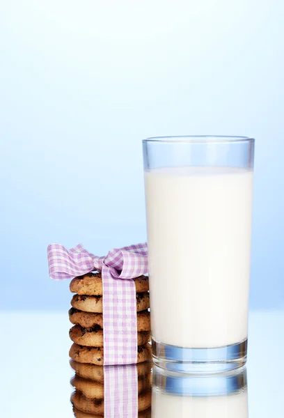 Glass of milk and cookies on blue background — Stock Photo, Image