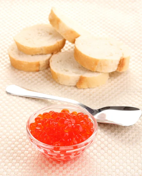 Caviar rojo en tazón de cristal con pan y cuchara sobre tela — Foto de Stock