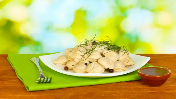 Pyszne pierogi gotowane w naczyniu na jasnym tle zielony — Zdjęcie stockowe