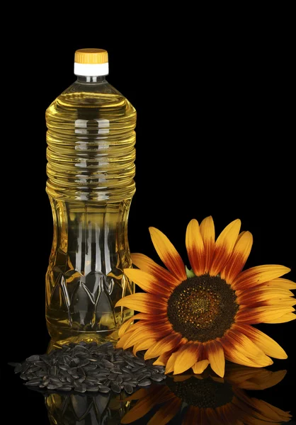 在黑色背景上孤立一个塑料瓶中的向日葵油 — 图库照片