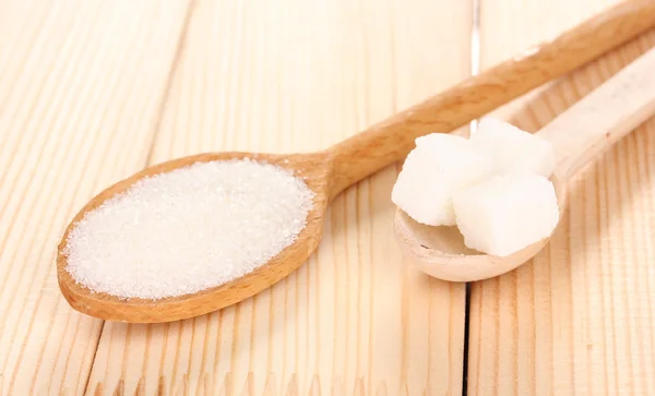 White sugar in spoons on wooden background — Stock Photo, Image