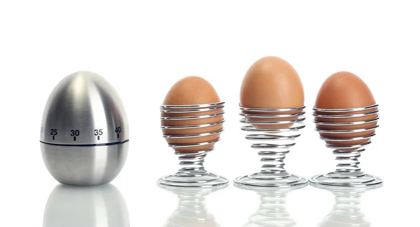 Temporizador de ovo e ovo em suporte de metal isolado em branco — Fotografia de Stock