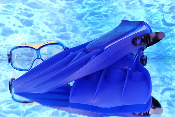 Blauwe flippers en masker op blauwe zee achtergrond — Stockfoto