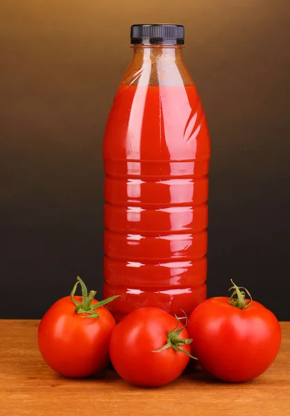 Jugo de tomate en botella sobre mesa de madera sobre fondo marrón —  Fotos de Stock