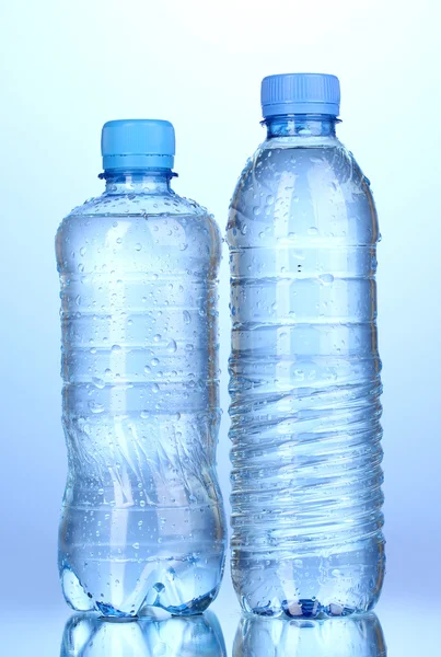 Garrafas de plástico de água no fundo azul — Fotografia de Stock