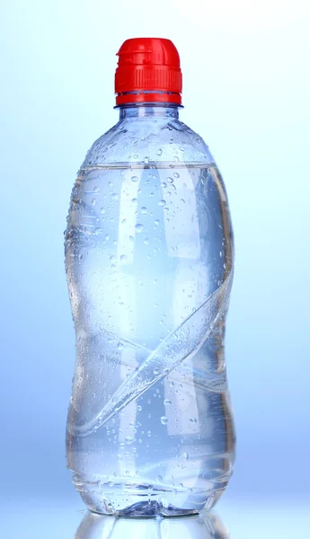 Plastic fles water op blauwe achtergrond — Stockfoto