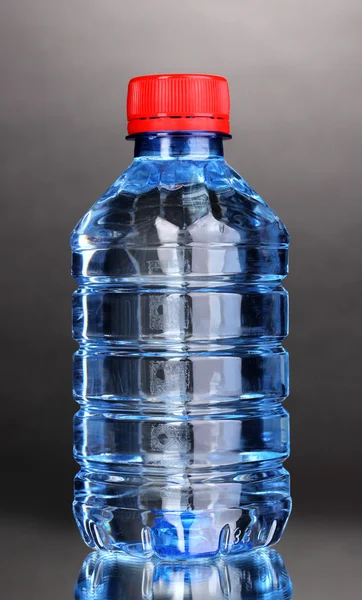 Plastic bottle of water on grey background — Stock Photo, Image