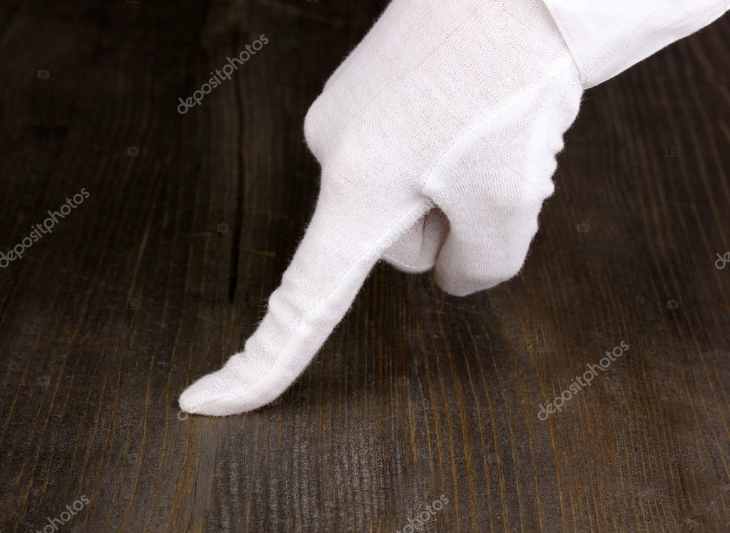 Female hand checking cleanliness on wooden background