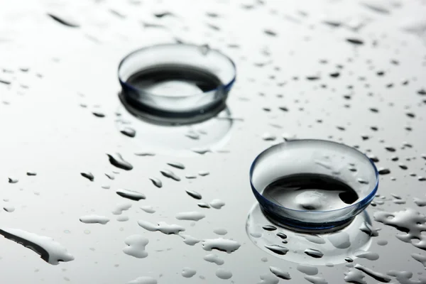 Contact lens with drops on grey background — Stock Photo, Image
