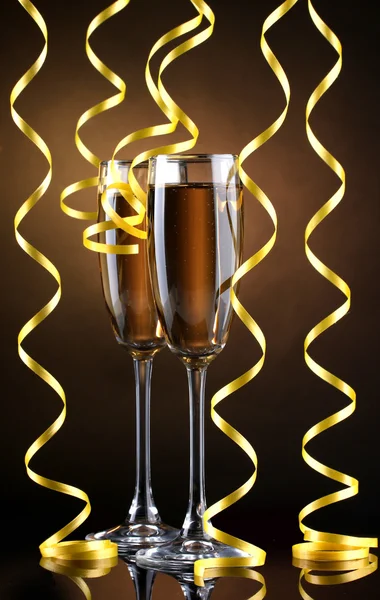 シャンパンと茶色の背景にストリーマーのメガネ — ストック写真