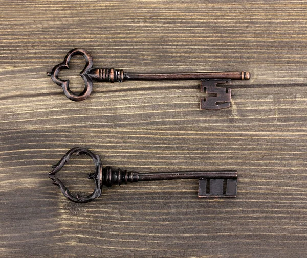 Два старинных ключа на деревянном фоне — стоковое фото