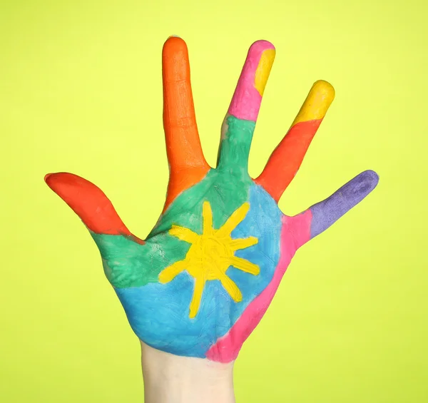 Brightly colored hand on green background close-up — Stock Photo, Image