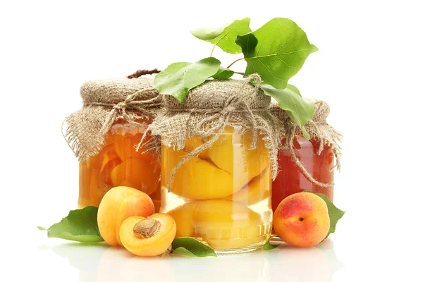 Marillendosen und Marmelade in einem Glas mit süßen Aprikosen isoliert auf weiß — Stockfoto