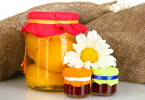 Jar з консервованими фруктами на фоні полотна крупним планом — стокове фото