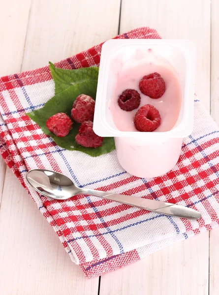 Jogurt s malinami na dřevěné pozadí — Stock fotografie