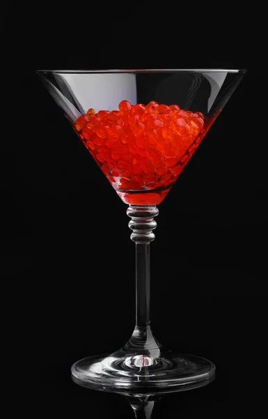 Caviar vermelho em vidro isolado em preto — Fotografia de Stock