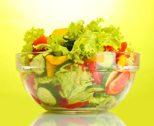 Salada de legumes frescos em tigela transparente no fundo verde — Fotografia de Stock