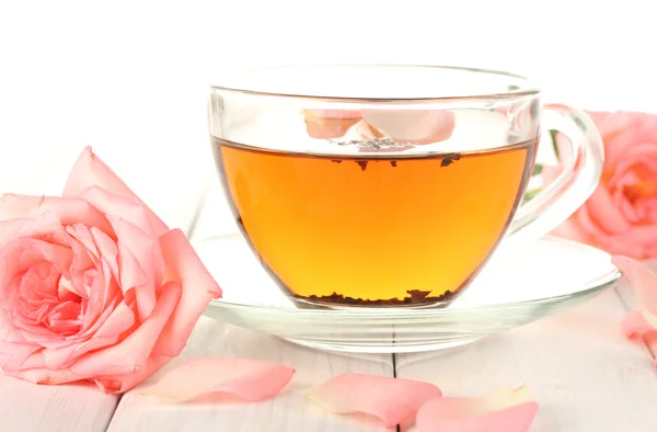 Šálek čaje s růží na bílý dřevěný stůl — Stock fotografie
